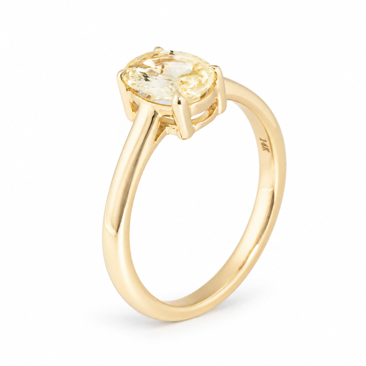 Angled studio photograph of the yellow sapphire solitaire, showcasing its softly coloured gemstone and elegant raised gold setting.