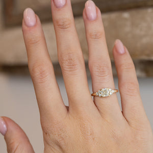 Diamond cluster engagement ring worn on a hand, showcasing its elegant proportions and vintage-inspired design.