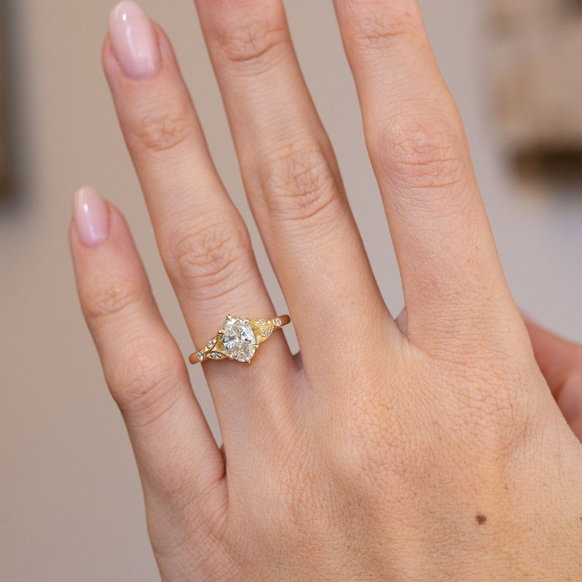 Natural hand view of the vintage-inspired ring and its delicate botanical proportions.