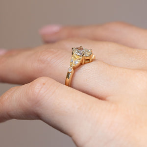 Side angle revealing the raised diamond setting and sculpted laurel-leaf design.