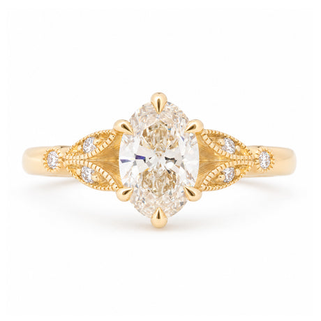Vintage-inspired pale yellow diamond engagement ring with decorative laurel-leaf trefoil shoulders in yellow gold.