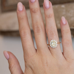 Yellow diamond cluster engagement ring worn on a hand, showcasing its elegant proportions and antique-inspired design.