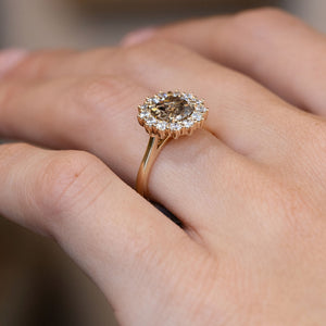 Side-angle view of the old-mine diamond cluster ring worn on a hand, highlighting the elevated setting and delicate gold band.