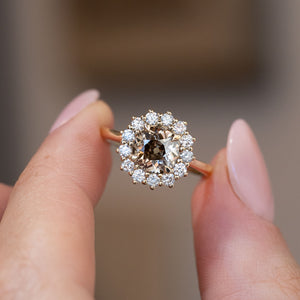 Hand-held close-up of the smoky cognac centre diamond surrounded by brilliant white diamonds in a floral-inspired cluster.