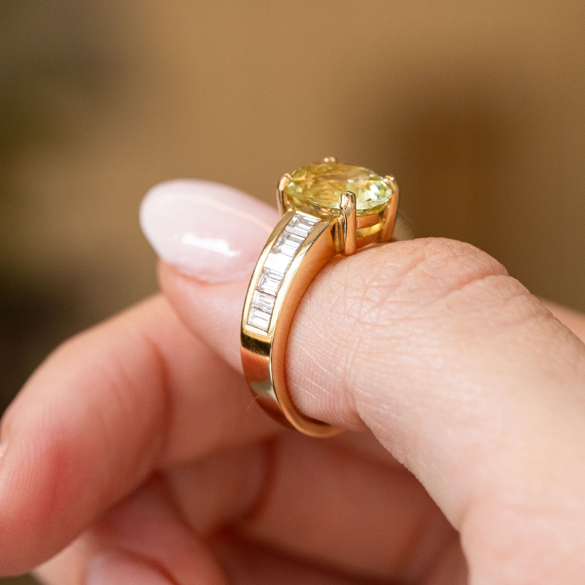 Profile view of a vintage 1980s engagement ring, showing the elevated green beryl setting and substantial 18ct yellow gold band.