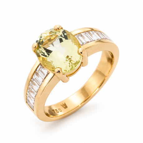 Angled product view of a vintage oval green beryl solitaire ring, flanked by channel-set baguette diamonds in polished 18ct yellow gold.