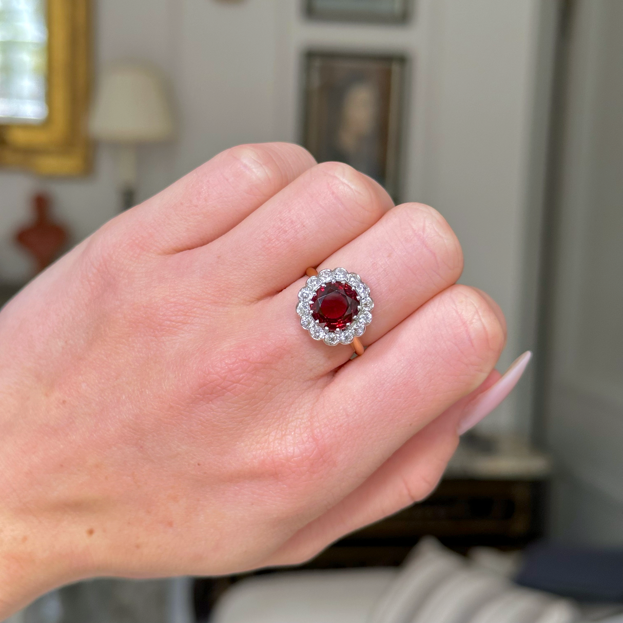 Edwardian garnet and diamond cluster ring, worn on hand.