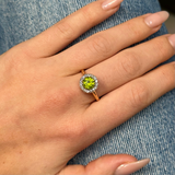 Edwardian peridot and diamond cluster ring, worn on hand.