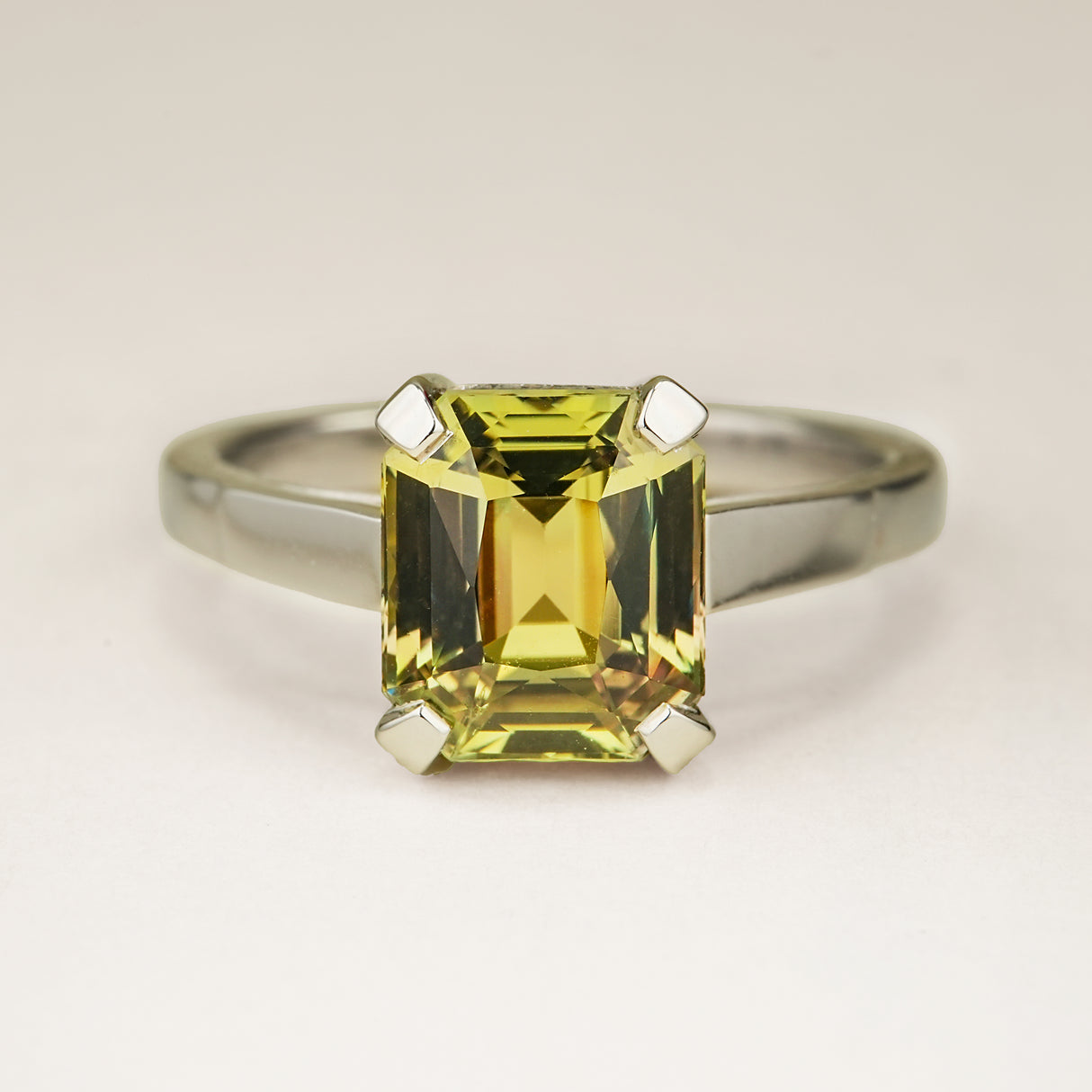 Green and brown colour-change sapphire solitaire engagement ring