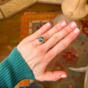 Green teal sapphire soliatire ring worn on the hand showing proportions