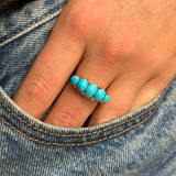 turquoise five stone half hoop ring, worn on hand and placed in pocket of jeans, front view. 