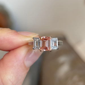 Lab-Pink Diamond & White Diamond Three-Stone Ring being held at Distance for scale.