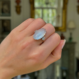 Moonstone and diamond ring, worn on closed hand.