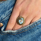 aquamarine ring with naturalistic textured yellow gold band on hand in jeans pocket.