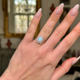Edwardian opal and diamond cluster ring worn on hand. 