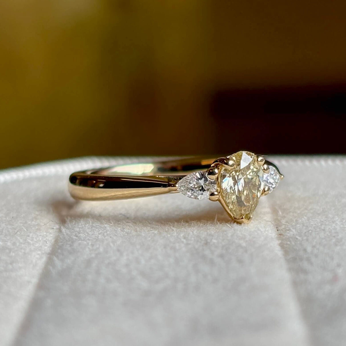 Pear-cut diamond three-stone engagement ring angled side on to show proportions of the three diamonds. 