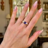 antique sapphire and pearl three stone ring worn on hand.