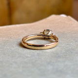 Reverse of a round-cut teal sapphire and diamond three-stone engagement ring, clearly showing the hallmarks and maker’s marks on the band.