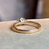 Reverse of round teal sapphire and pear-cut diamond three-stone engagement ring, clearly showing the hallmarks and maker’s marks on the band.