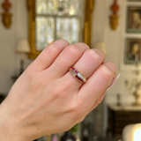 Ruby and diamond half eternity ring worn on closed hand. 