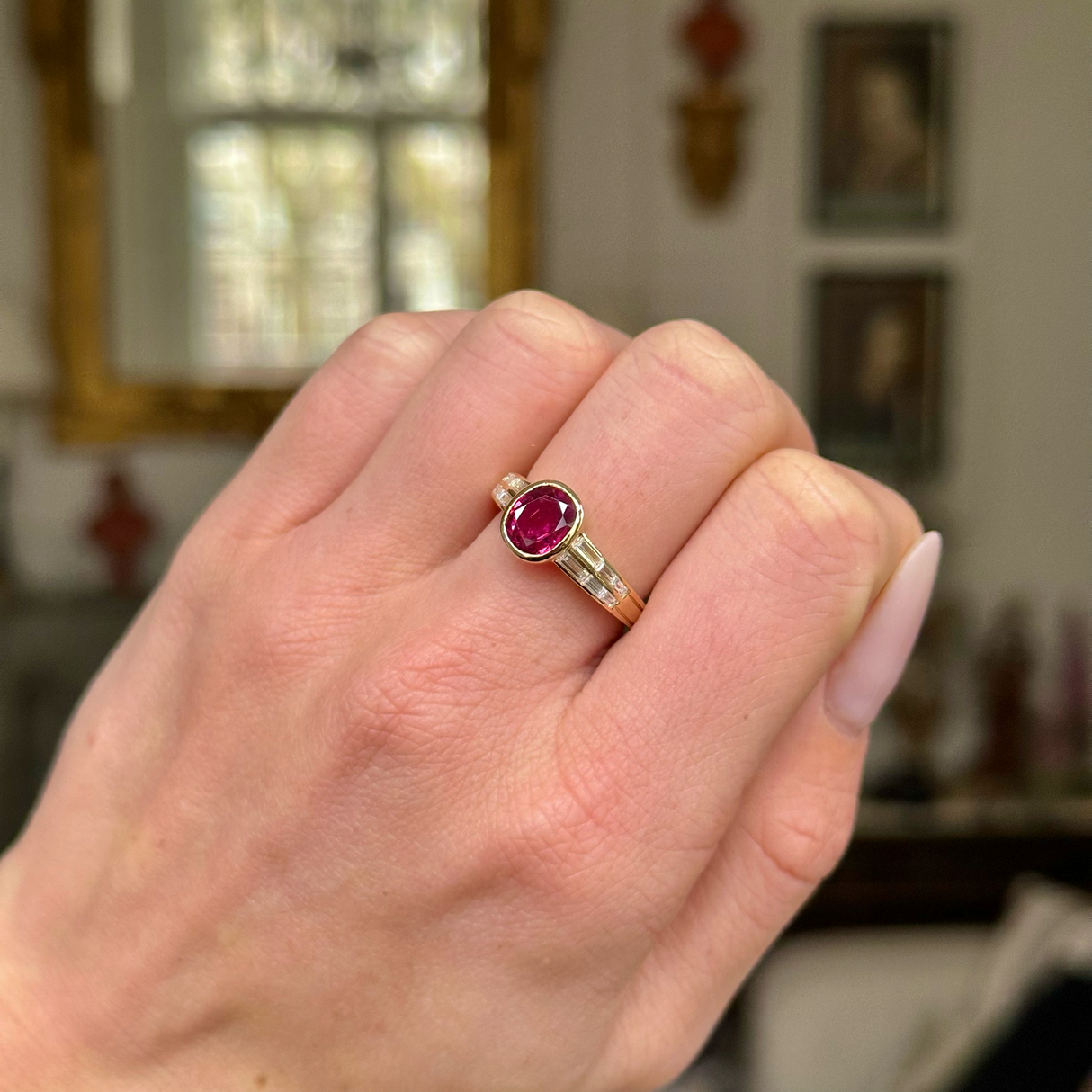 Art Deco ruby and diamond ring worn on closed hand. 