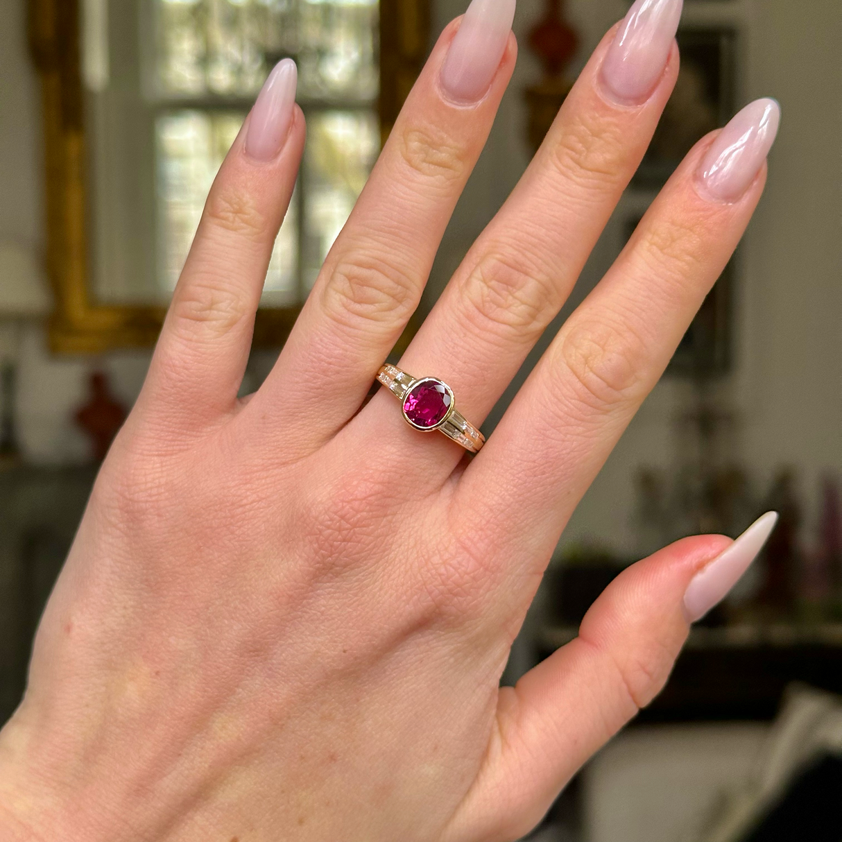 Art Deco ruby and diamond ring worn on hand. 