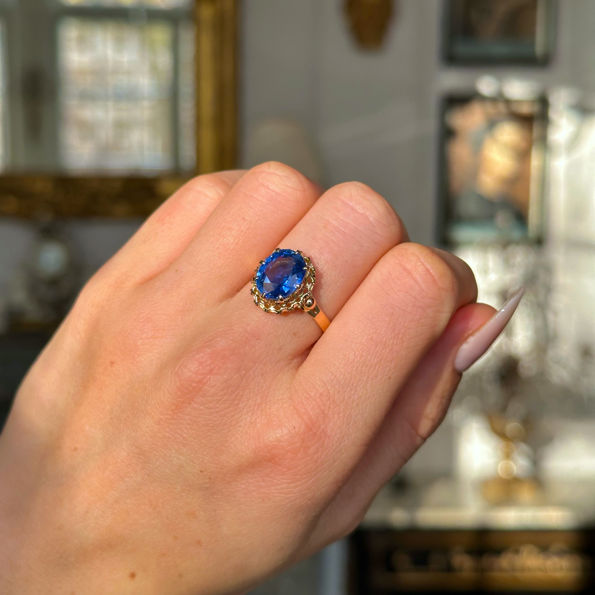 sapphire and yellow gold engagement ring worn on closed hand. 