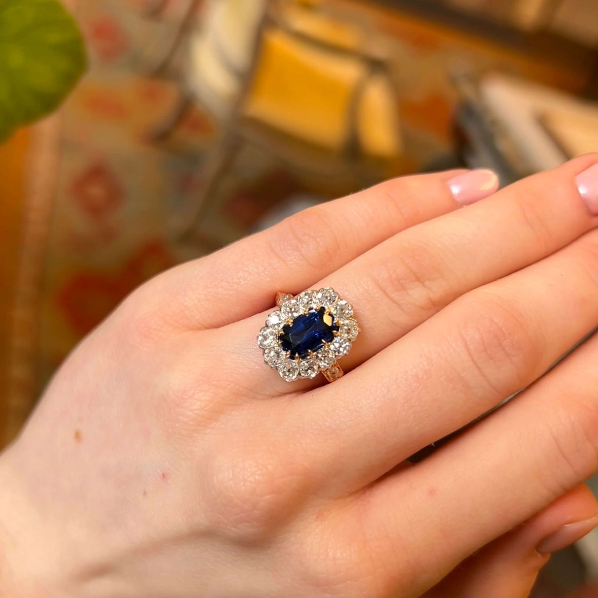 Sapphire and diamond antique cluster ring being worn on the hand