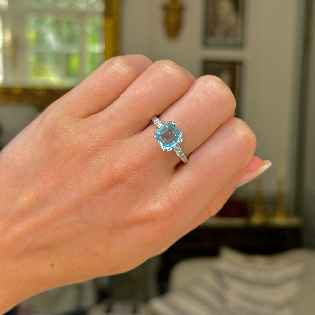 vintage aquamarine and diamond ring worn on closed hand. 