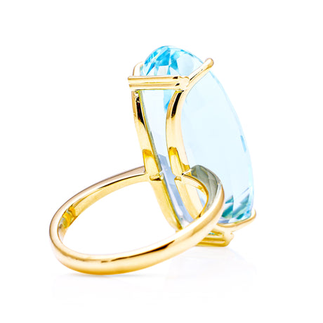 Large aquamarine and yellow gold cocktail ring on a white background, back of ring perspective. 