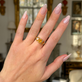 Three stone citrine ring worn on hand.