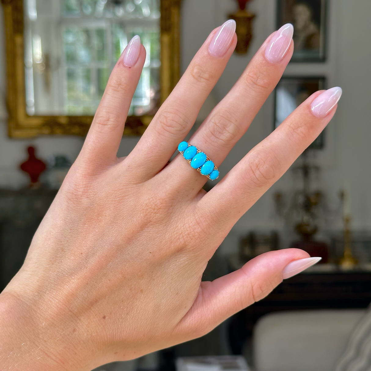 turquoise five stone half hoop ring, worn on hand,  front view. 