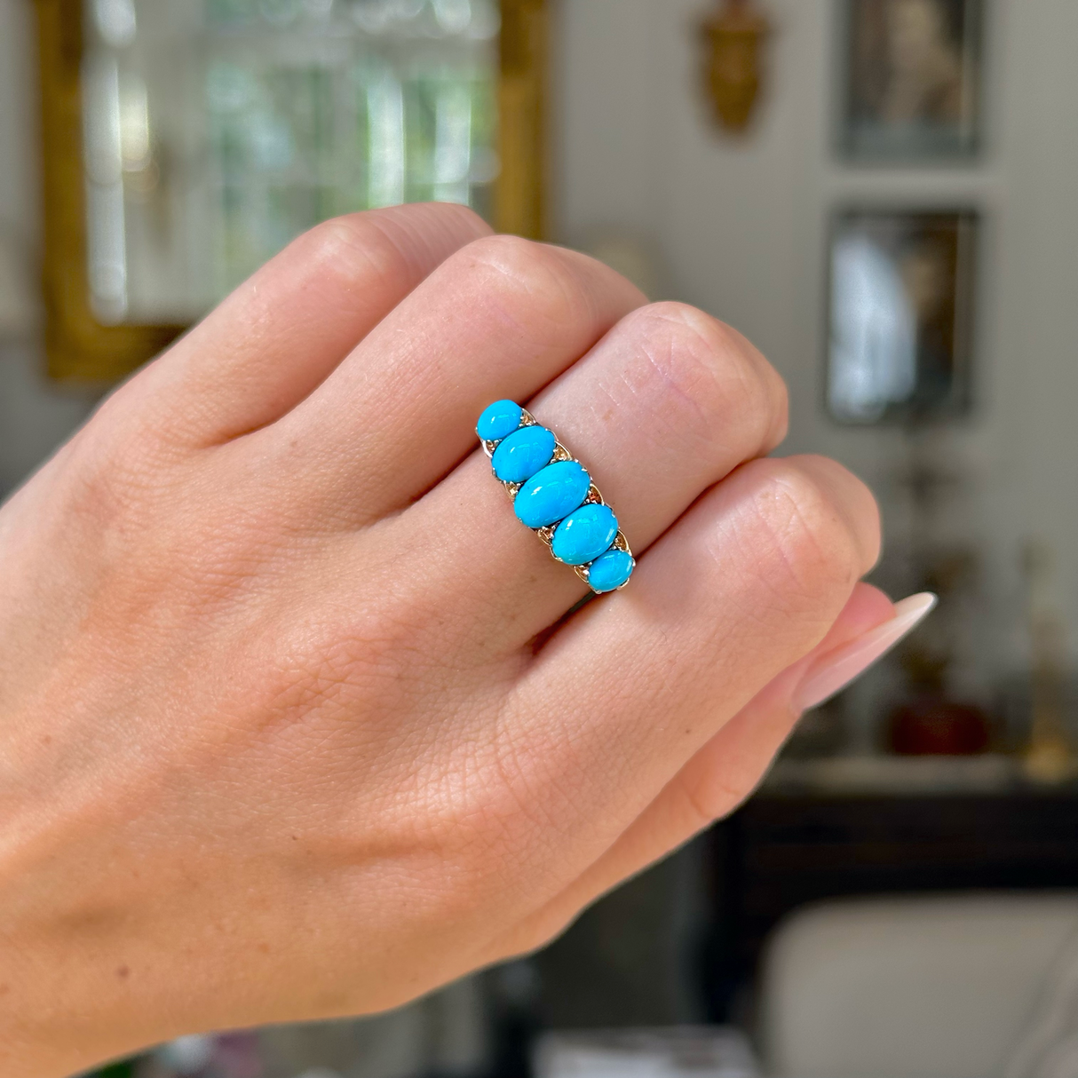 turquoise five stone half hoop ring, worn on closed hand,  front view. 
