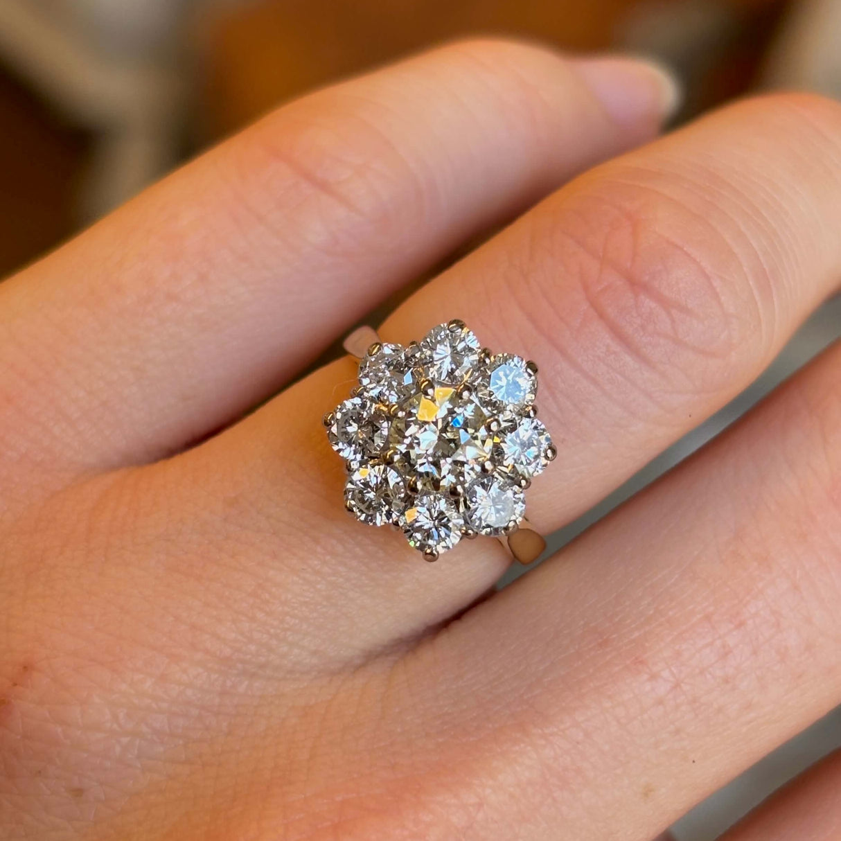 Vintage, 1980's diamond cluster ring worn on ring finger of left hand captured close up to show the diamonds clarity