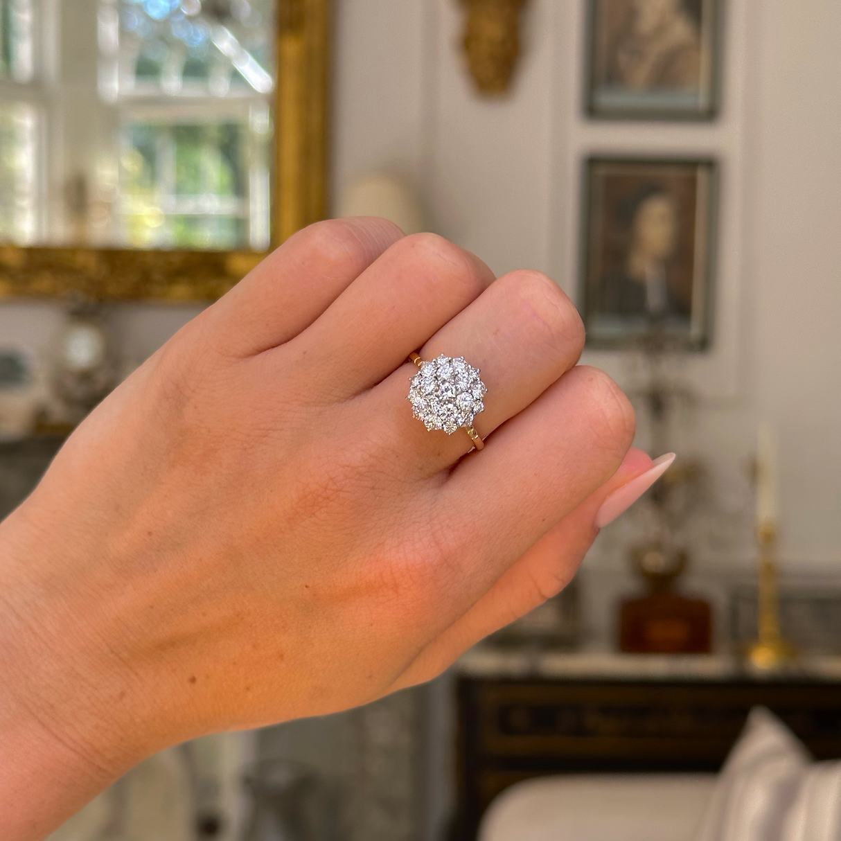 1980s diamond cluster engagement ring worn on closed hand.