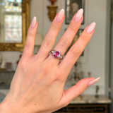 vintage pink sapphire, diamond and platinum ring worn on hand. 