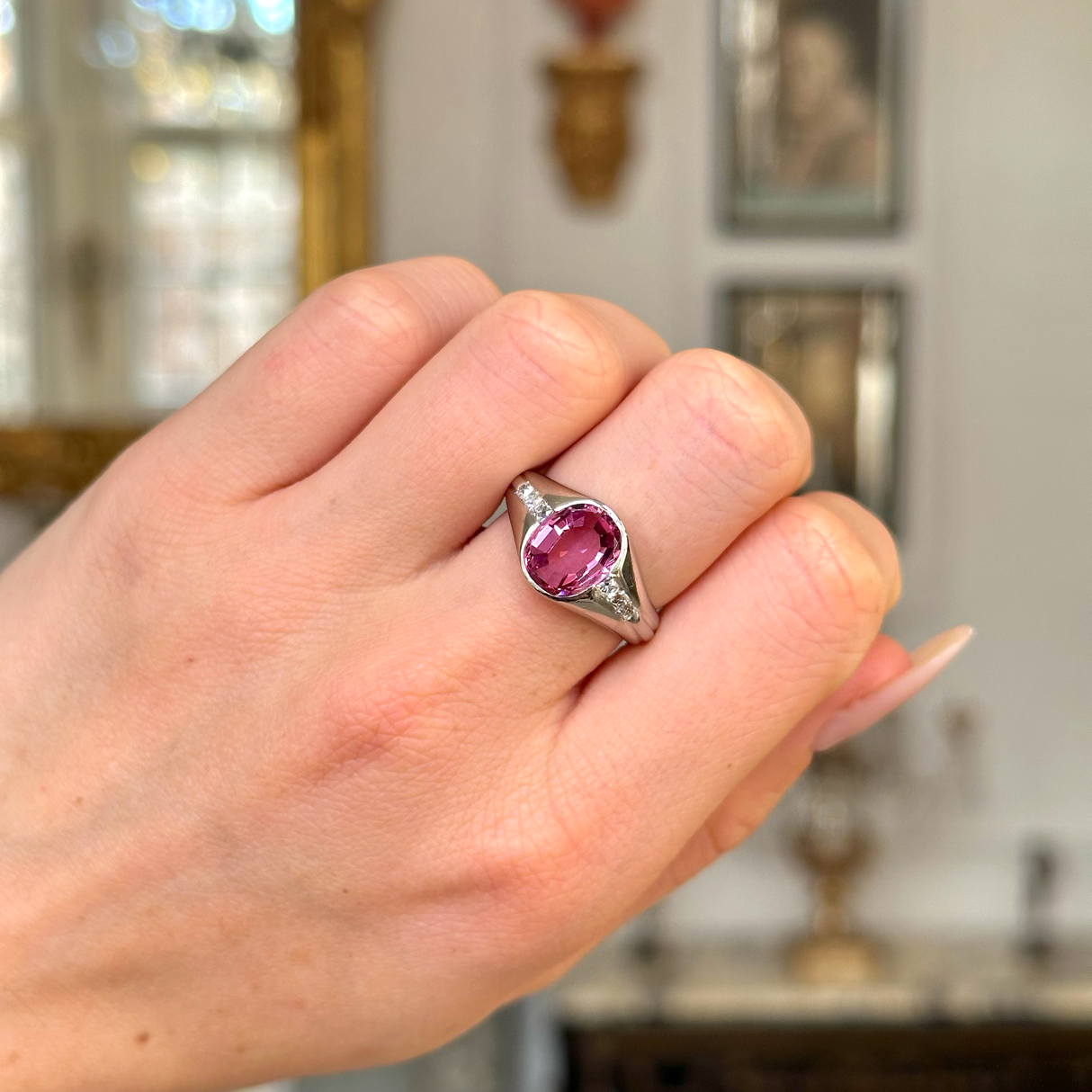 vintage pink sapphire, diamond and platinum ring worn on closed hand. 