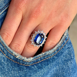 A vintage sapphire and diamond cluster ring worn on hand in pocket of jeans.