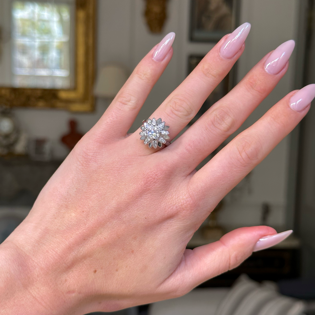 french diamond engagement ring resembling a flower worn on hand, front view. 