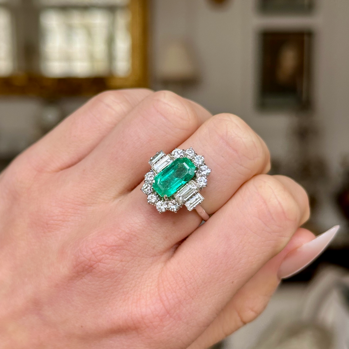 Vintage emerald and diamond cluster ring, worn on closed hand. 
