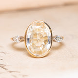 A yellow and white gold vintage ring with a large yellow sapphire flanked by two marquise diamonds.