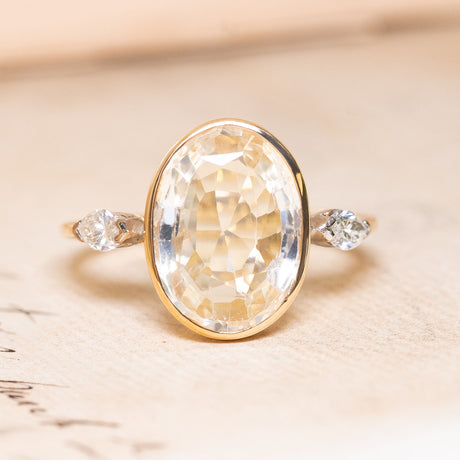 A yellow and white gold vintage ring with a large yellow sapphire flanked by two marquise diamonds.
