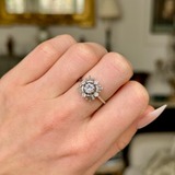 Vintage diamond cluster ring worn on closed hand, front view.