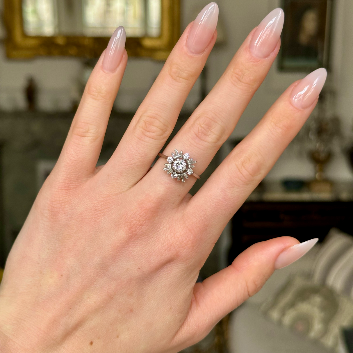 Vintage diamond cluster ring worn on hand, front view.