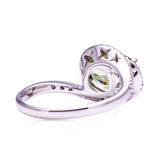 Green sapphire and diamond ring, back perspective on a white background.