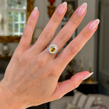 Yellow sapphire and diamond cluster engagement ring, on hand.