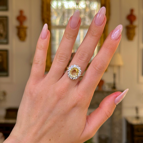 yellow sapphire and diamond cluster ring worn on hand. 