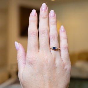 Antique 1920s sapphire and diamond three-stone ring worn on hand.