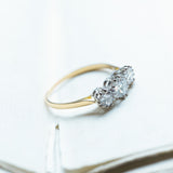 Antique Art Deco diamond three-stone ring with graduated diamonds and yellow gold band.