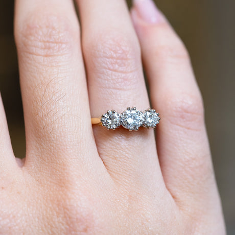 Antique Art Deco diamond three-stone ring with graduated diamond setting and yellow gold band.
